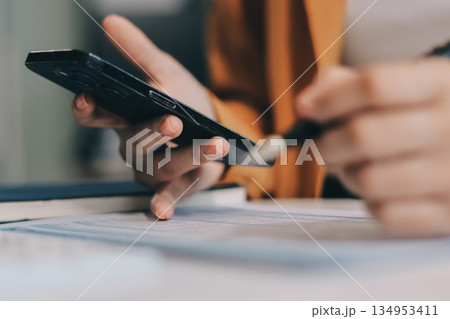 Business woman using calculator for do math finance on wooden desk in office and business working background, tax, accounting, statistics and analytic research concept. 134953411