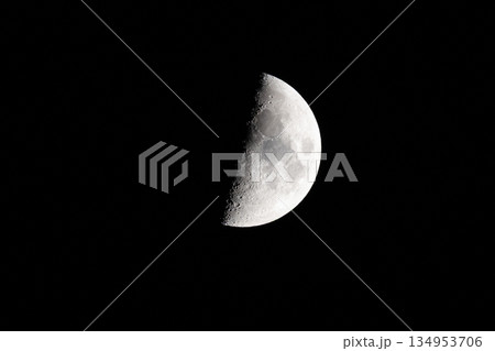 Half moon with detailed craters glowing in a night sky, minimalist astronomy background 134953706