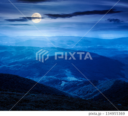 mountain landscape with rolling hills at night. summer countryside scenery with view in to the distant valley and forested slopes in full moon light. finance investment or abstract concepts 134955369