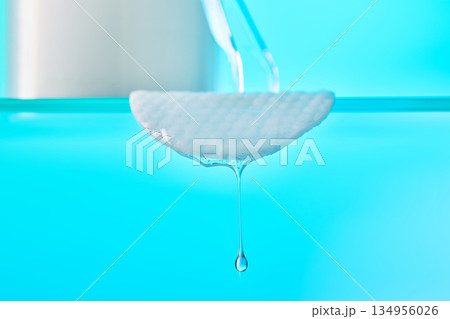 Cotton pad dropping liquid showing skincare purity and beauty Cotton pad dropping liquid showing skincare purity and beauty 134956026
