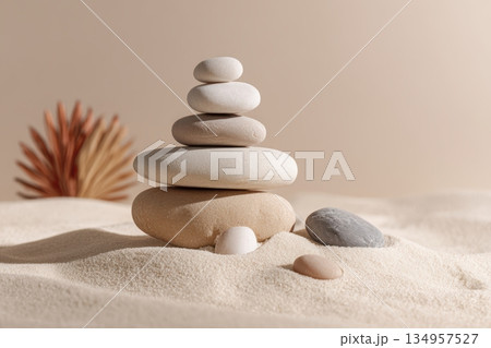 Stones stacked on sand in warm light 134957527