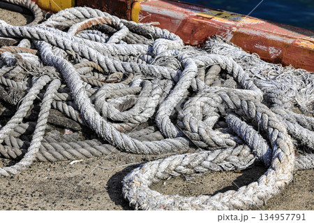 Mooring line on rusty pier bollard referred to a post on a ship or quay. 134957791