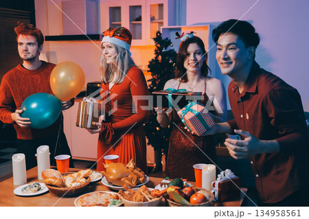 Festive Office Christmas Party with Delicious Food. A beautifully decorated office space with Christmas trees and festive lights, set up for a holiday party. 134958561