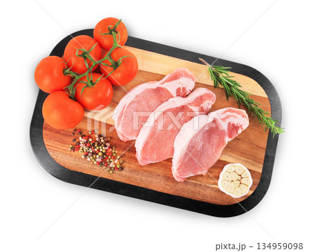 Fresh raw pork chops on wooden board with tomatoes, rosemary, garlic and peppercorns isolated on white background. High quality photo 134959098