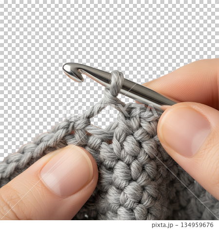 Close-up of a person's hands crocheting with a light grey yarn and a metal hook, showcasing the craft process for diy and hobby content Close-up of a person's hands crocheting with a light grey yarn and a metal hook, showcasing the craft process for diy and hobby content 134959676