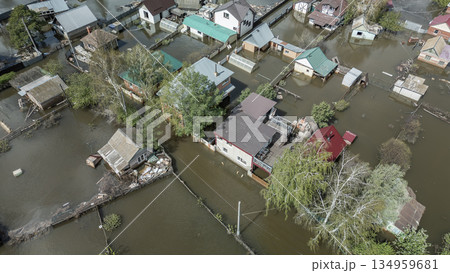 Aerial drone footage of a massive city flood with houses and streets submerged under water. Urban flooding caused by extreme weather and heavy rainfall, showing natural disaster impact on residential  134959681