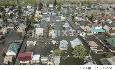 Aerial drone footage of a massive city flood with houses and streets submerged under water. Urban flooding caused by extreme weather and heavy rainfall, showing natural disaster impact on residential  134959688