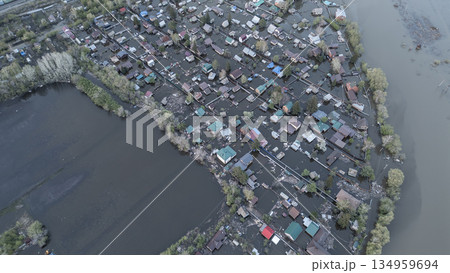 Aerial drone footage of a massive city flood with houses and streets submerged under water. Urban flooding caused by extreme weather and heavy rainfall, showing natural disaster impact on residential  134959694