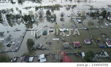 Aerial drone footage of a massive city flood with houses and streets submerged under water. Urban flooding caused by extreme weather and heavy rainfall, showing natural disaster impact on residential  134959708