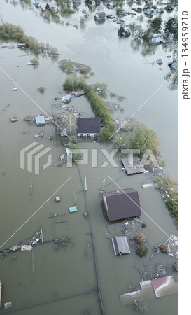 Aerial drone footage of a massive city flood with houses and streets submerged under water. Urban flooding caused by extreme weather and heavy rainfall, showing natural disaster impact on residential  134959710