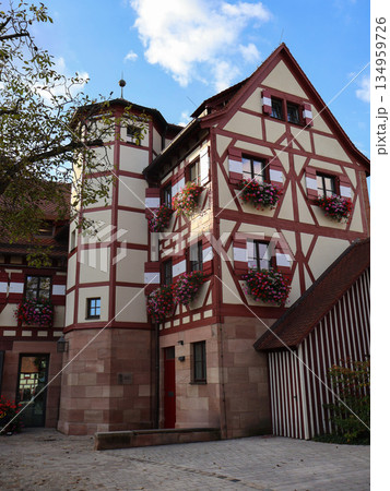 Charming Half-Timbered House With Flower Boxes In Cobblestone Courtyard, European Village Charm Charming Half-Timbered House With Flower Boxes In Cobblestone Courtyard, European Village Charm 134959726