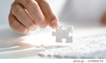 パズルのピースをはめるビジネスマンの手 134960254