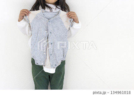 赤ちゃんの頃の服を持った女の子(5歳、日本人) 赤ちゃんの頃の服を持った女の子(5歳、日本人) 134961018