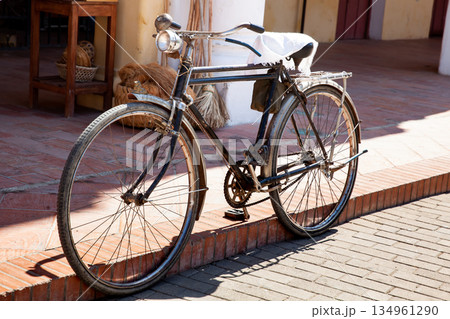 Old bicycle parked on the street. Old rusty bicycle in the beautiful Heritage Town of Santa Cruz de Mompox. Old bicycle parked on the street. Old rusty bicycle in the beautiful Heritage Town of Santa Cruz de Mompox. 134961290