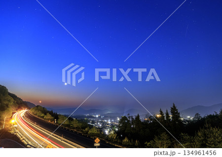 春の星景色　明け方の空に昇る月と金星　高速道路の車の軌跡 134961456