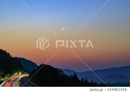 春の星景色　明け方の空に昇る月　高速道路の車の軌跡 134961458