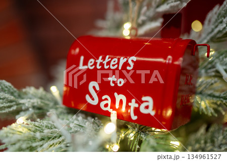 Red Christmas mailbox for Santa hanging on snowy pine branch Red Christmas mailbox for Santa hanging on snowy pine branch 134961527