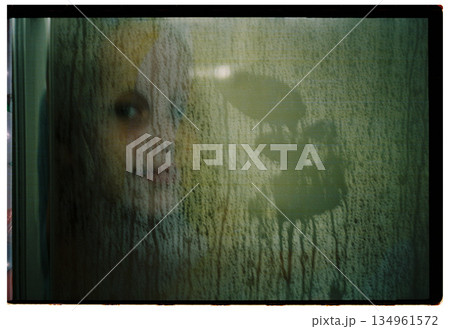 Child face behind foggy glass with condensation on film 134961572