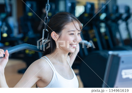 スポーツジムでトレーニングする若い女性 スポーツジムでトレーニングする若い女性 134961619