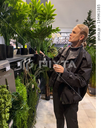 Woman selecting houseplants in a garden store Woman selecting houseplants in a garden store 134961885