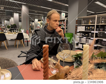 Woman in store pondering tableware display Woman in store pondering tableware display 134961906