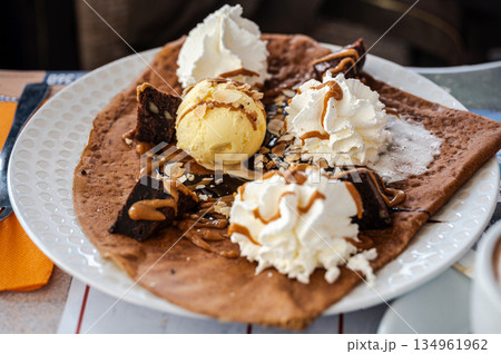 Homemade buckwheat crepes. Galettes bretonnes with icecream on a colorful background.. Traditional French cuisine. Homemade buckwheat crepes. Galettes bretonnes with icecream on a colorful background.. Traditional French cuisine. 134961962