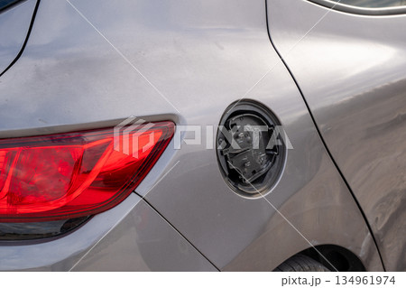 Rear view of gray car with missing fuel cap cover 134961974