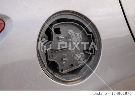 Broken plastic fuel cover compartment on gray vehicle 134961976