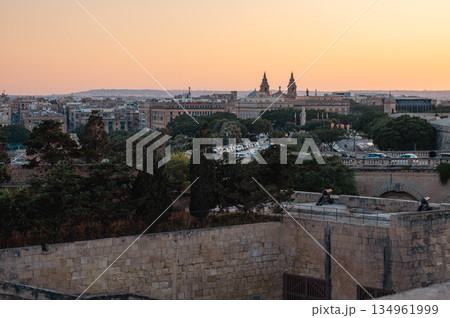 A stunning panoramic view of Birgu Port as seen from a Valletta vantage point, showcasing historic architecture, docked boats, and the scenic Maltese coastline. 134961999