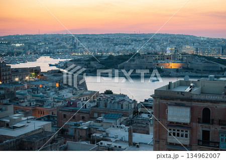 A stunning aerial view of Valletta's rooftops, showcasing the city's historic architecture, domes, and limestone buildings under the Mediterranean sky. 134962007