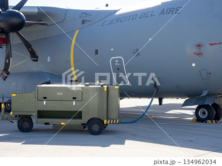Military airlifter on ground with connected power unit Military airlifter on ground with connected power unit 134962034