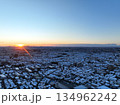 ＜空撮＞昇る朝日と雪の降った朝の都会 134962242