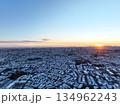 ＜空撮＞昇る朝日に照らされる雪の降った朝の都区内 134962243