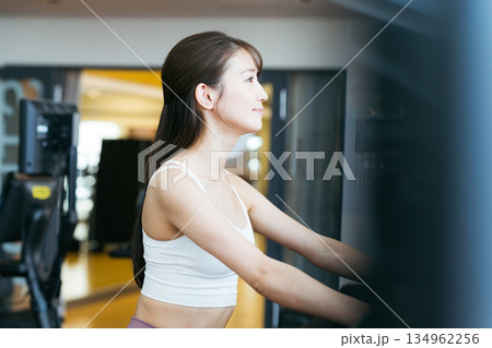 スポーツジムでトレーニングする若い女性 スポーツジムでトレーニングする若い女性 134962256