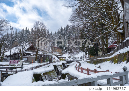 雪に覆われた寺院参道と水路｜静寂に包まれた冬の日本の風景 134962787