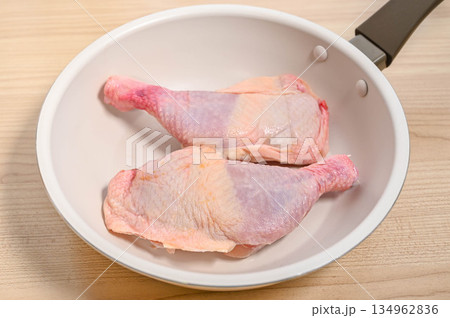 フライパンに入れた調理前の骨付きチキン フライパンに入れた調理前の骨付きチキン 134962836