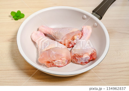 フライパンに入れた調理前の骨付きチキン フライパンに入れた調理前の骨付きチキン 134962837