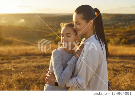Mother Embracing Daughter During Nature Walk On Mother Day Celebration 134964091