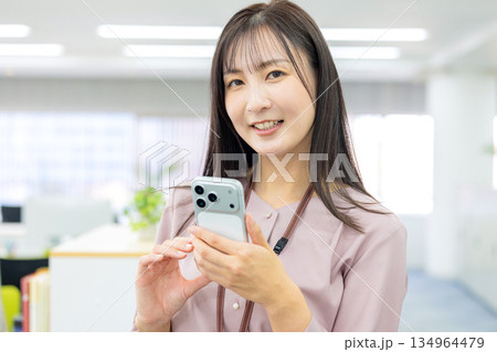 スマホを操作するビジネスウーマン スマホを操作するビジネスウーマン 134964479