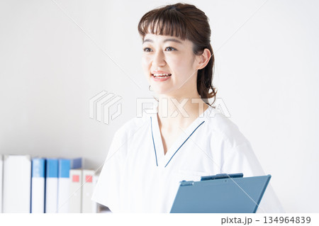 笑顔でファイルを持つ白衣の女性 134964839