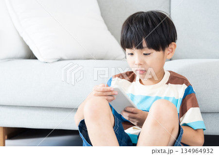 リビングでスマホで遊ぶ小学生男子 134964932