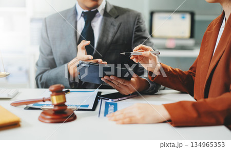 Lawyer consulting client with legal documents and scales of justice on desk. Concept of law, contract, consultation, and professional legal service. Lawyer consulting client with legal documents and scales of justice on desk. Concept of law, contract, consultation, and professional legal service. 134965353