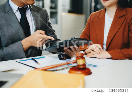 Lawyer consulting client with legal documents and scales of justice on desk. Concept of law, contract, consultation, and professional legal service. 134965355