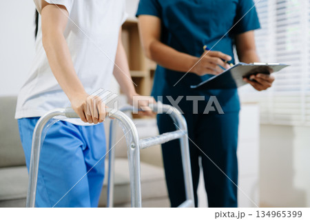 Healthcare professional assisting a patient in physiotherapy rehab using a walker, symbolizing recovery, mobility support, Healthcare professional assisting a patient in physiotherapy rehab using a walker, symbolizing recovery, mobility support, 134965399