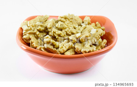 Walnut Kernels in Orange Ceramic Bowl Isolated on White. High quality photo 134965693
