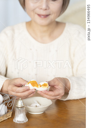 ゆで卵を食べるシニア女性 アウトフォーカス ゆで卵を食べるシニア女性 アウトフォーカス 134966495