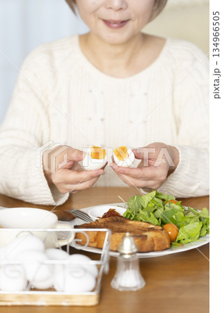ゆで卵を食べるシニア女性 アウトフォーカス ゆで卵を食べるシニア女性 アウトフォーカス 134966505