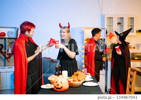 Joyful office Halloween party with coworkers in costumes, celebrating with drinks and laughter, fostering teamwork and festive spirit Joyful office Halloween party with coworkers in costumes, celebrating with drinks and laughter, fostering teamwork and festive spirit 134967041