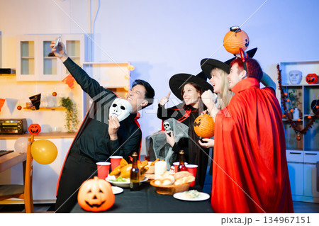 Halloween party react with surprise and laughter to spooky props like pumpkins and a ghost skeleton. Perfect seasonal fun, decor, and festive vibes. Halloween party react with surprise and laughter to spooky props like pumpkins and a ghost skeleton. Perfect seasonal fun, decor, and festive vibes. 134967151