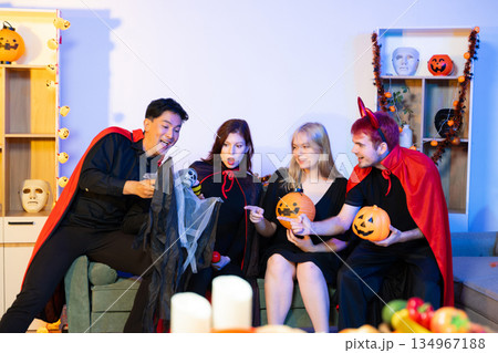 Joyful office Halloween party with coworkers in costumes, celebrating with drinks and laughter, fostering teamwork and festive spirit 134967188